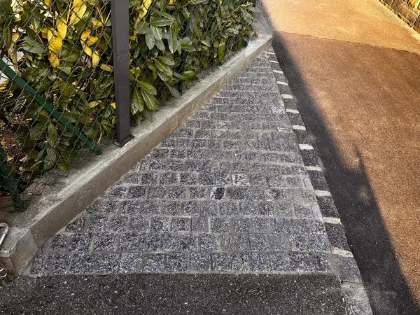Piazzale in porfido posato a ventaglio con cordoli in granito, realizzato in Ticino