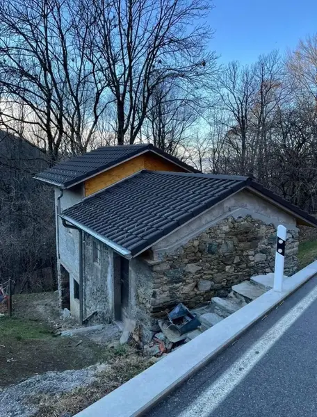 Rustico con tetto rifatto a due falde, tegole scure e finiture in legno