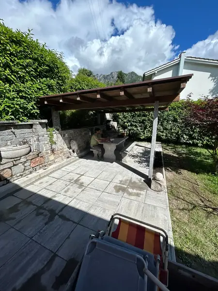 Terrazza esterna con piastrelle grigie di grande formato e giardino