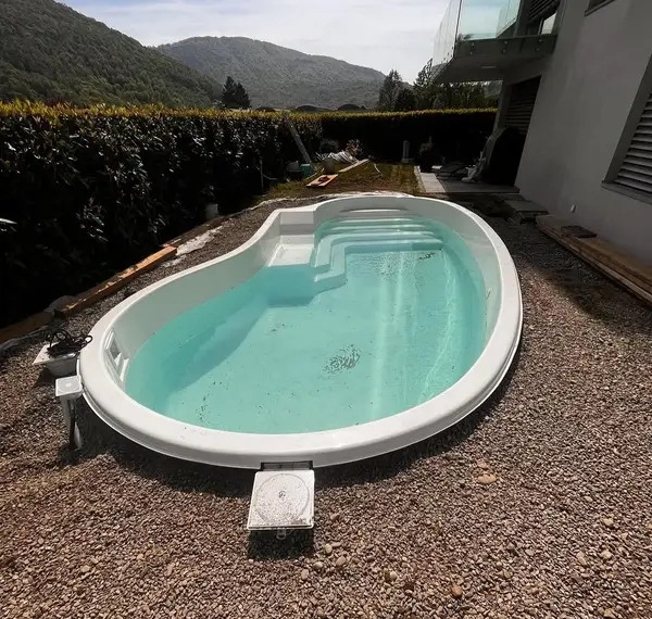 Piscina interrata prefabbricata posata nel terreno, pronta per le finiture